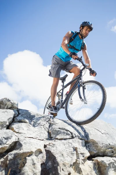 Człowiek na rowerze na skalistym terenie — Zdjęcie stockowe
