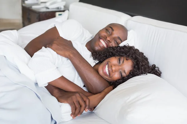 Happy couple lying in bed together — Stock Photo, Image
