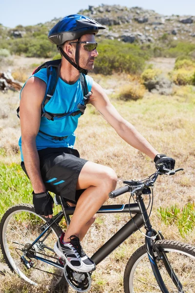 Přizpůsobit cyklista na koních v krajině — Stock fotografie