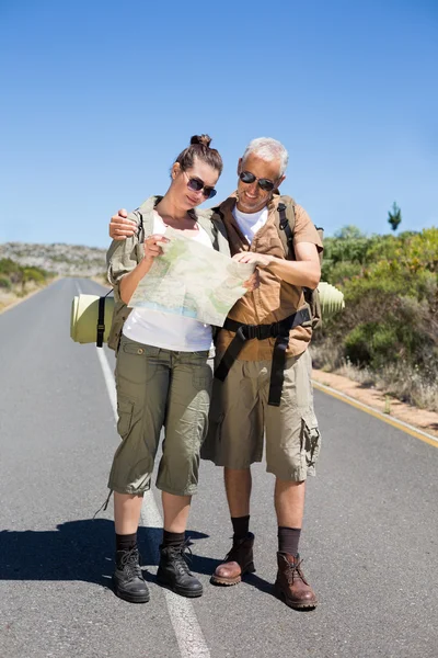 Couple randonnée regardant la carte sur la route — Photo