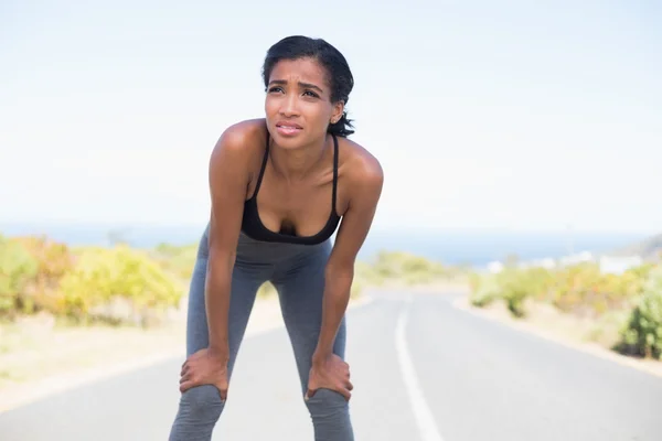 Mujer en forma tomando un descanso en el camino abierto —  Fotos de Stock