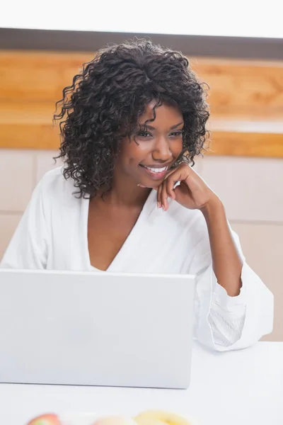 Mujer bonita en albornoz usando el ordenador portátil en la mesa —  Fotos de Stock