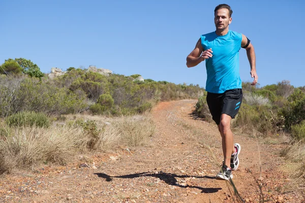 Atletisk man jogging på land trail — Stockfoto