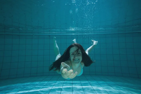 Morena bonita sorrindo e oferecendo a mão debaixo d 'água — Fotografia de Stock