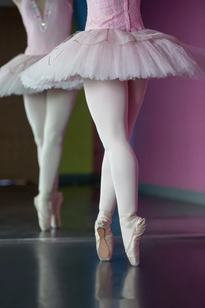 Изящная балерина, стоящая на пуантах перед зеркалом — стоковое фото