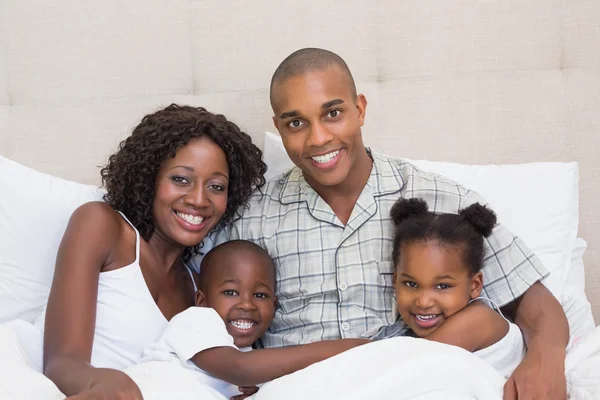 Feliz família abraçando na cama juntos — Fotografia de Stock