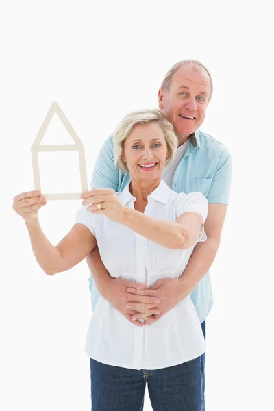 Happy older couple holding house shape — Stock Photo, Image