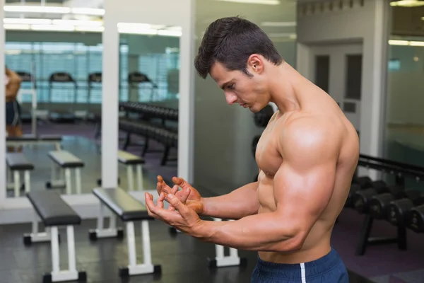 Sin camisa musculoso hombre posando en gimnasio — Foto de Stock