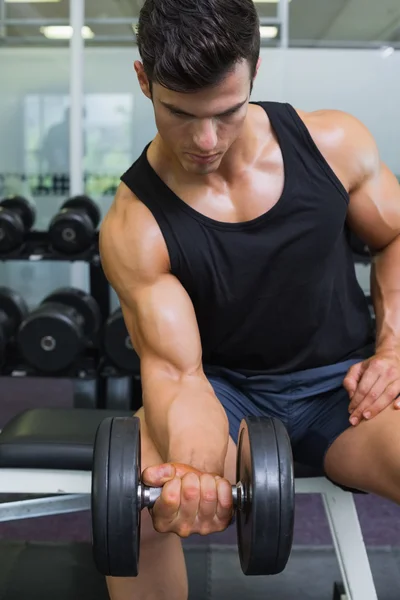 Gespierde man uitoefenend met halter in gym — Stockfoto
