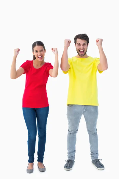 Excited couple cheering in red and yellow tshirts — Stock Photo, Image