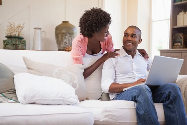 Couple together on the couch using laptop — Stock Photo, Image