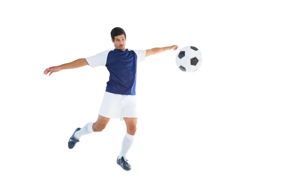 Football player in blue kicking ball — Stock Photo, Image