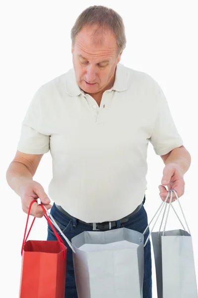 Zralý muž při pohledu na jeho nákupy — Stock fotografie