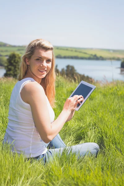 Pretty blonde using her tablet smiling at camer — Stock Photo, Image