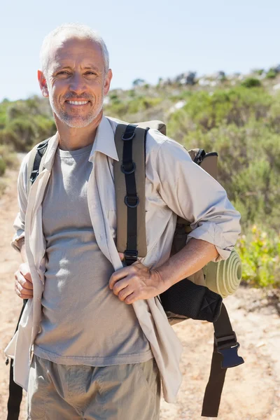 Caminante guapo sonriendo a la cámara en el campo —  Fotos de Stock