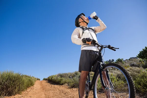Passen wielrenner drinkwater op land terrein — Stockfoto