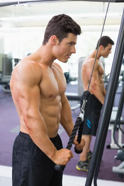 Hombre musculoso sin camisa usando tríceps tire hacia abajo en el gimnasio — Foto de Stock