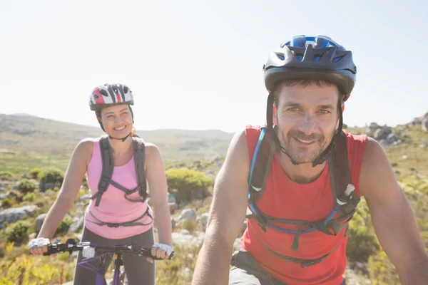 Fit cyclist couple riding together on mountain trail — Stock Photo, Image