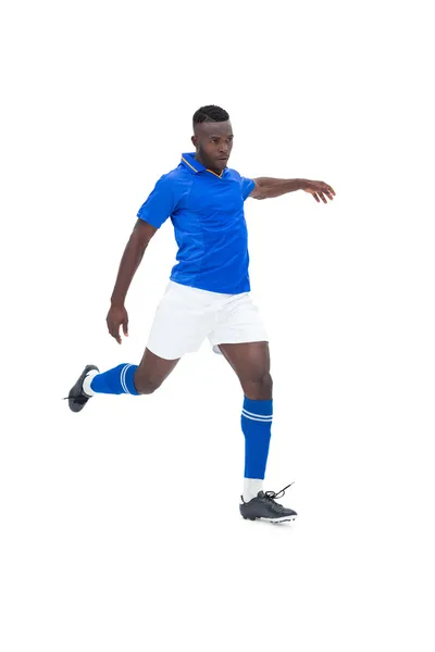 Jogador de futebol em azul chutando — Fotografia de Stock