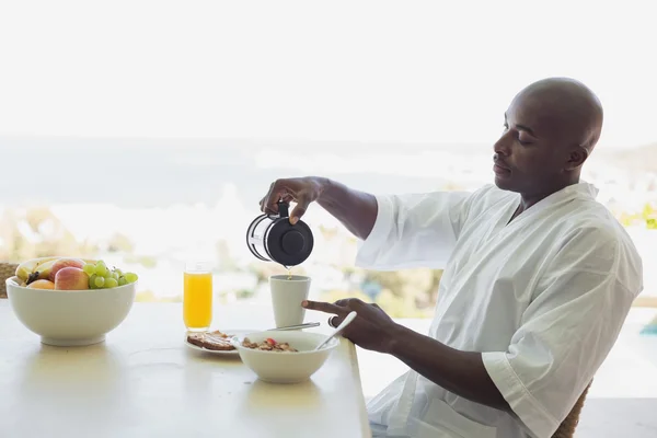 Handsome man in bathrobe having breakfast outside — Stock Photo, Image