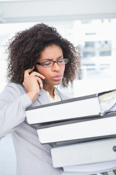 Femme d'affaires occasionnelle parlant au téléphone tenant pile de documents — Photo