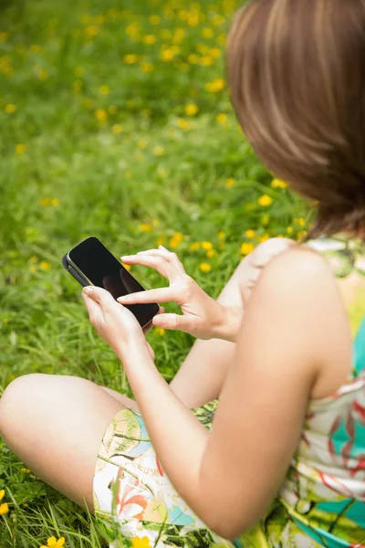 Vrouw van het tekstoverseinen in veld — Stockfoto