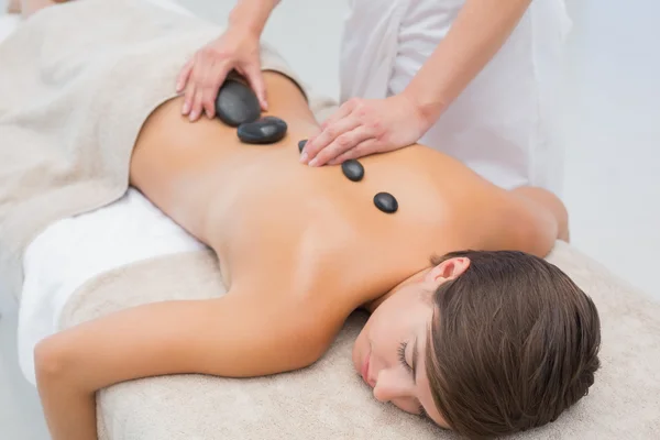 Mooie vrouw ontvangen stenen massage in het wellness center — Stockfoto