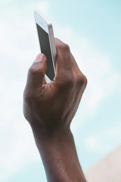 Hombre sosteniendo teléfono inteligente en la mano — Foto de Stock