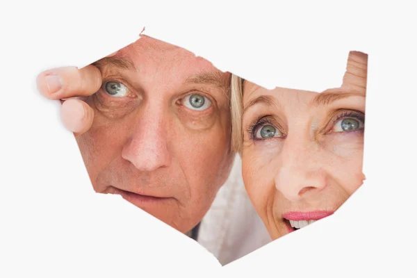 Older couple looking through rip — Stock Photo, Image