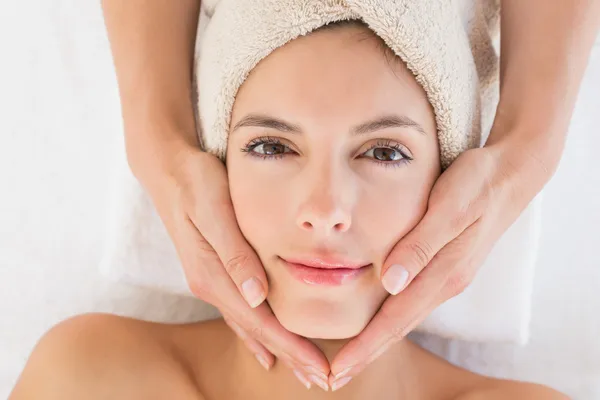 Приваблива молода жінка отримує масаж обличчя в спа-центрі — стокове фото