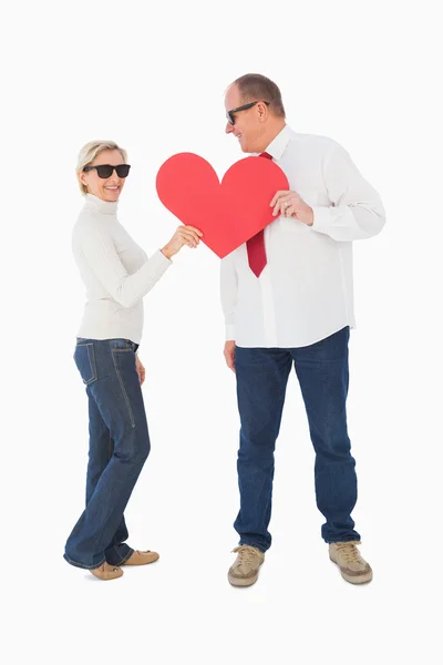 Older affectionate couple holding red heart shape — Stock Photo, Image