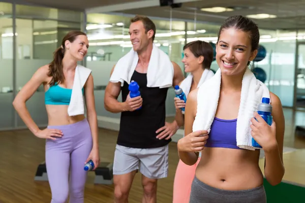 Fit woman smiling at camera in busy fitness studio — Stock Photo, Image