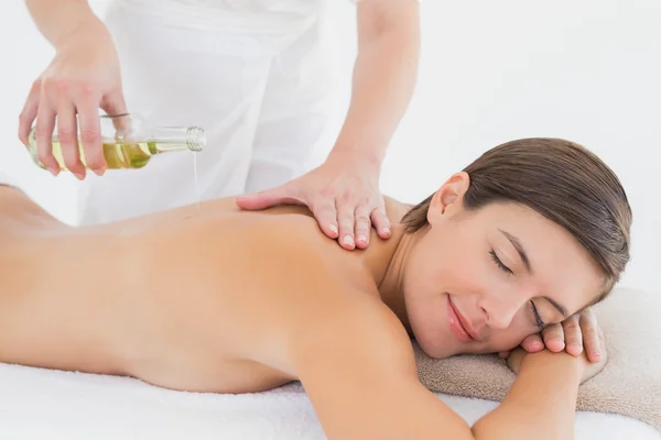 Atractiva mujer recibiendo aceite de masaje en su espalda — Foto de Stock