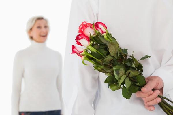 Homem escondendo buquê de rosas da mulher mais velha — Fotografia de Stock