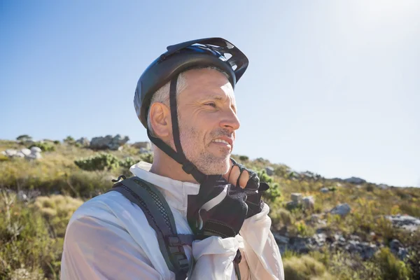 Passar cyklist justera hjälmen bandet på land terräng — Stockfoto