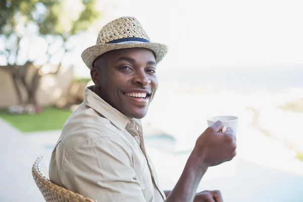 Uomo sorridente che si rilassa nel suo giardino prendendo un caffè — Foto Stock