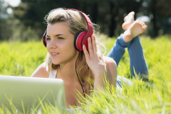 Ładna blondynka za pomocą laptopa, słuchanie muzyki — Zdjęcie stockowe