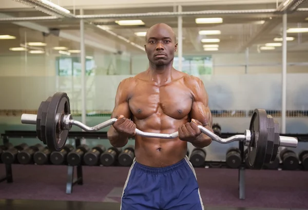 Musculoso hombre levantando barra en gimnasio —  Fotos de Stock