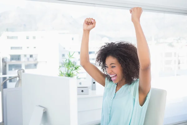 Casual businesswoman cheering at her desk — Stock Photo, Image