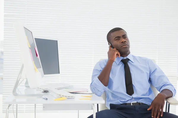 Affärsman som sitter vid sitt skrivbord på telefonen — Stockfoto