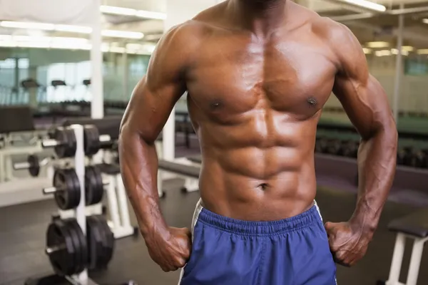 Mid section of a shirtless muscular man in gym — Stock Photo, Image