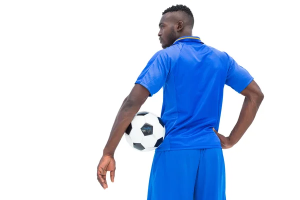 Jogador de futebol em azul segurando bola — Fotografia de Stock