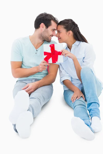 Bonito casal sentado segurando um presente — Fotografia de Stock