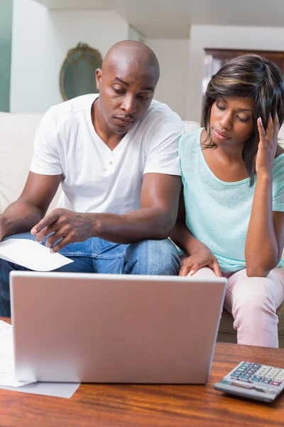 Pareja preocupada calculando facturas en el sofá — Foto de Stock