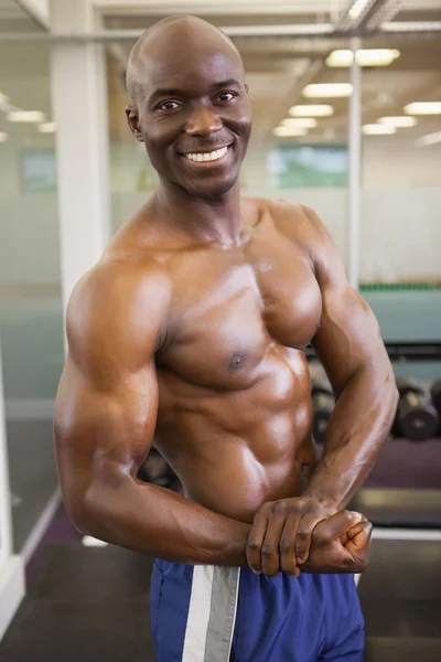 Sonriente sin camisa musculoso hombre posando en el gimnasio —  Fotos de Stock