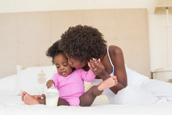 Genitori felici con la bambina sul loro letto — Foto Stock