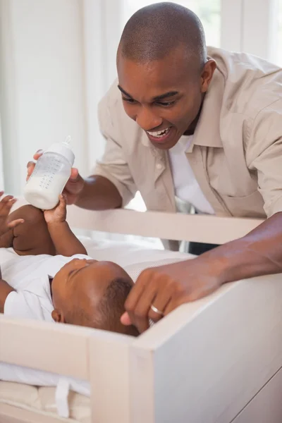 Happy father holding bottle for baby son — Stock Photo, Image