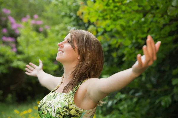 Woman with arms outstretched in field — Stock Photo, Image