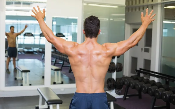 Culturista con brazos extendidos en el gimnasio — Foto de Stock