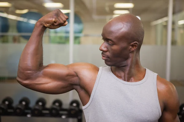 Muscular man flexing muscles in gym — Stock Photo, Image